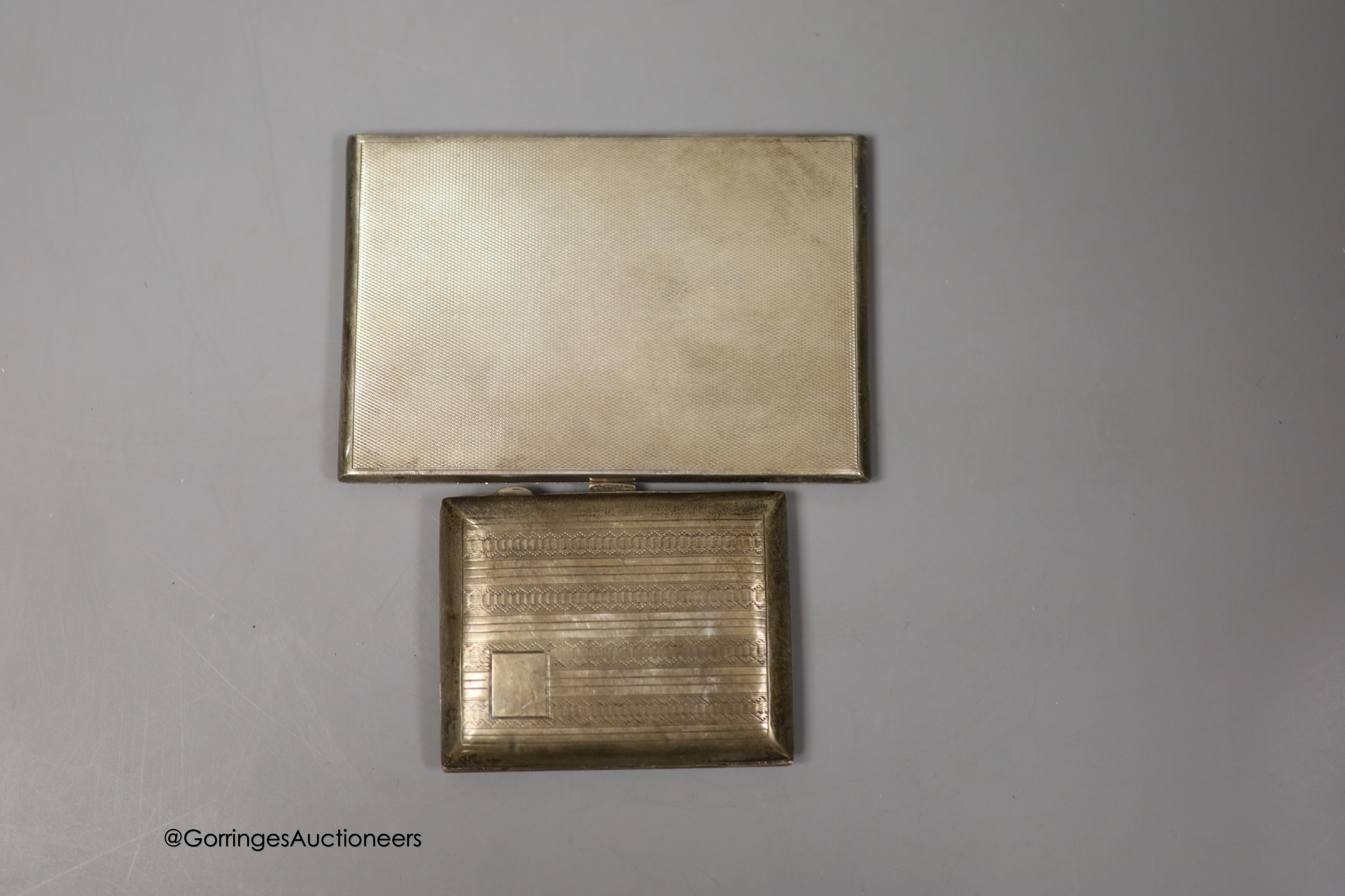 A George VI engine turned silver rectangular cigarette case, Goldsmiths & Silversmiths Co Ltd, London, 1940, 12.3cm and one other smaller silver cigarette case, gross 8.5oz.